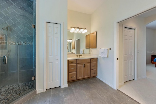 full bath with vanity, a shower stall, baseboards, and a closet