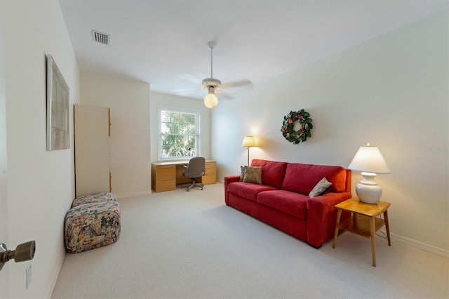 living area with visible vents, carpet flooring, baseboards, and a ceiling fan