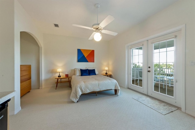 carpeted bedroom featuring visible vents, baseboards, french doors, arched walkways, and access to outside