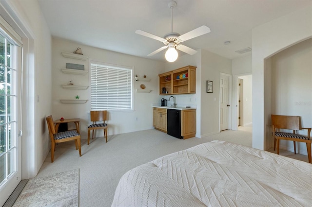 bedroom featuring a sink, visible vents, light colored carpet, and a ceiling fan