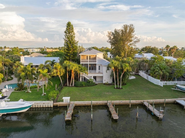 exterior space featuring a water view, a lawn, and fence