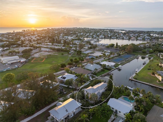 aerial view at dusk featuring a water view