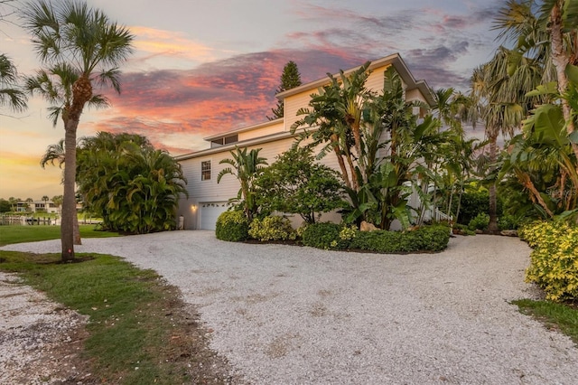 view of front of home featuring gravel driveway and an attached garage