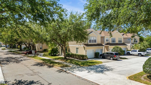 view of property featuring concrete driveway and an attached garage