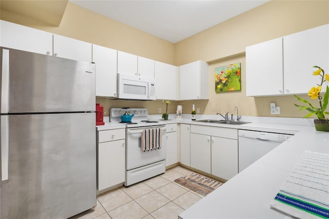 kitchen with light countertops, light tile patterned flooring, white appliances, white cabinetry, and a sink