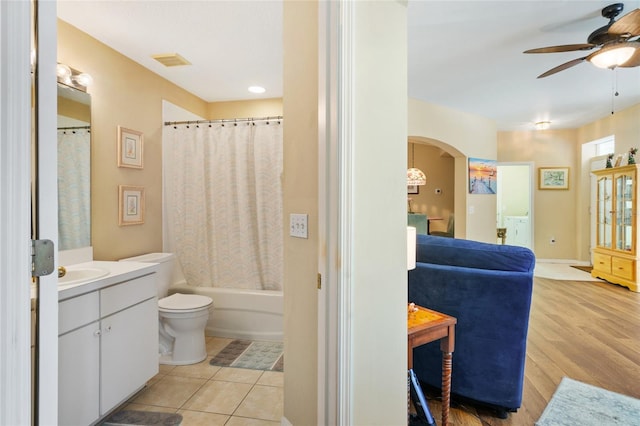 full bathroom featuring vanity, a ceiling fan, visible vents, shower / bath combo with shower curtain, and toilet