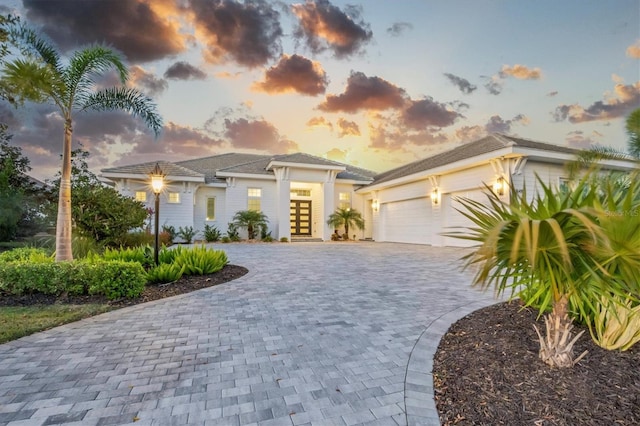 prairie-style house with french doors, decorative driveway, and a garage