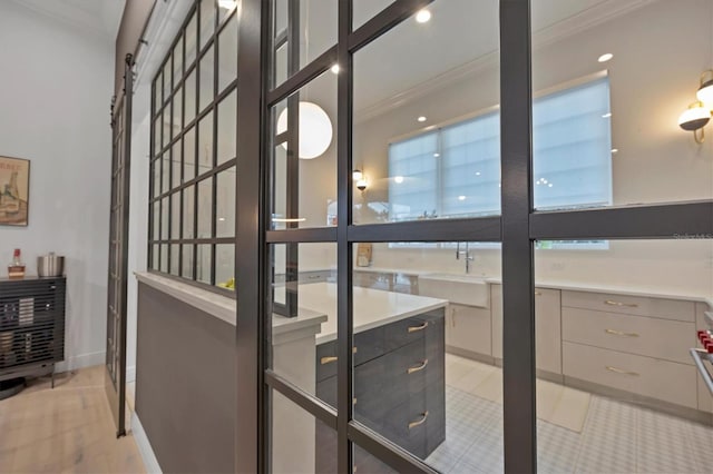 interior space with ornamental molding, baseboards, and a sink