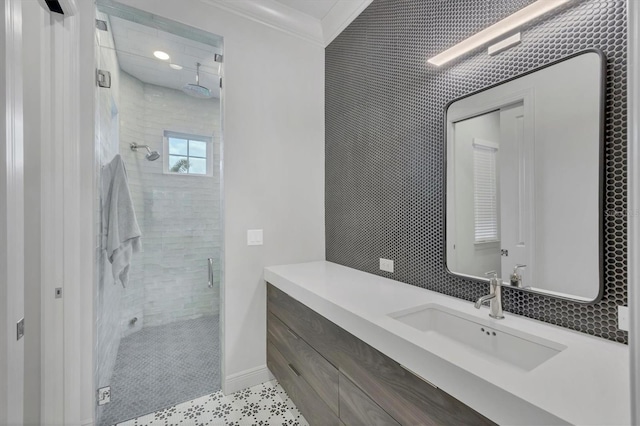 full bathroom featuring a shower stall, vanity, crown molding, and baseboards