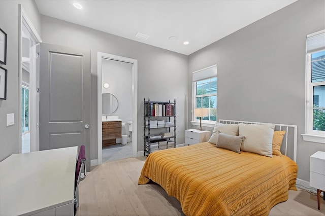 bedroom with visible vents, baseboards, ensuite bath, recessed lighting, and light wood-style floors