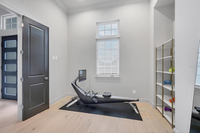 workout room featuring wood finished floors, baseboards, and ornamental molding