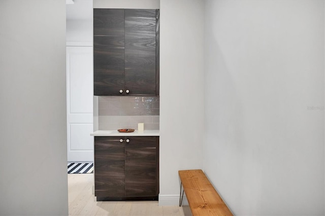 bar with backsplash and light wood-type flooring