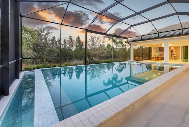 view of swimming pool with a lanai, a patio area, and an infinity pool