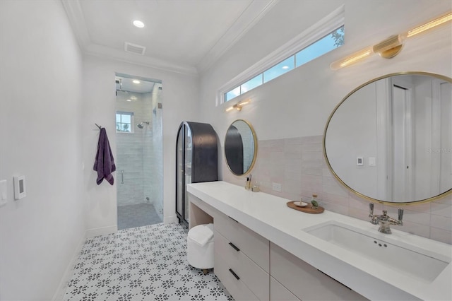 full bath with a tile shower, a healthy amount of sunlight, crown molding, and visible vents