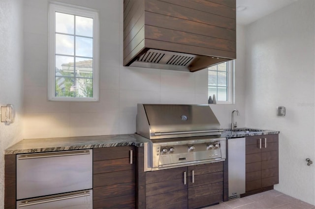 kitchen with refrigerator, modern cabinets, custom exhaust hood, and a sink