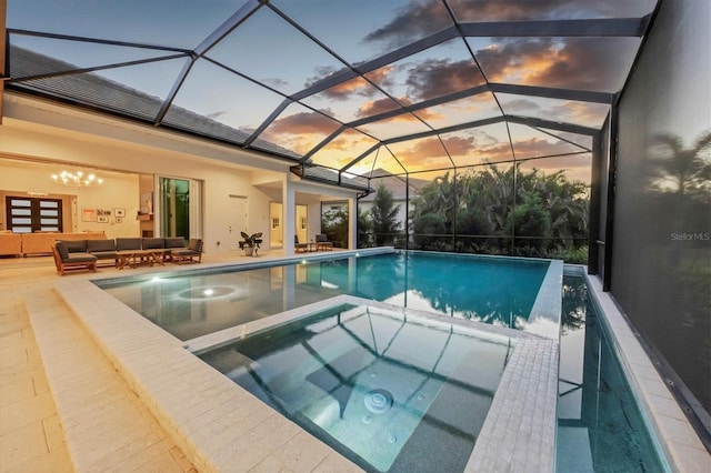 pool at dusk with a lanai, an outdoor living space, a patio area, and a pool with connected hot tub