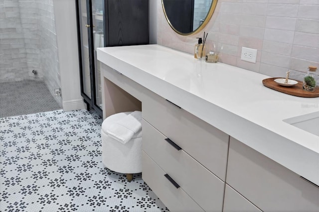 bathroom featuring tile patterned flooring, double vanity, and a stall shower