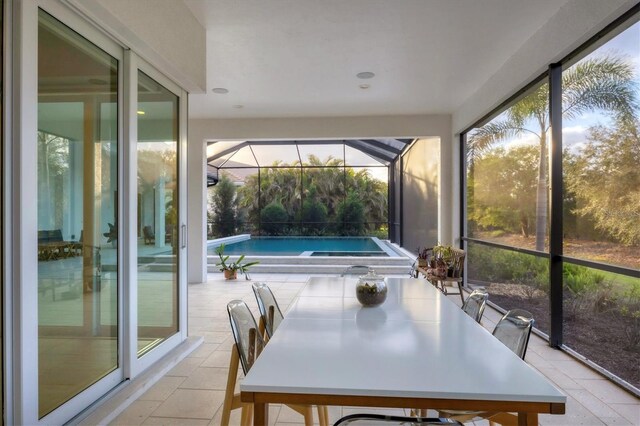 sunroom featuring outdoor dining space and a healthy amount of sunlight