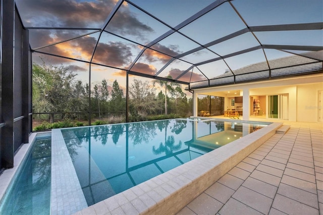 view of pool featuring a lanai, a patio, and an infinity pool