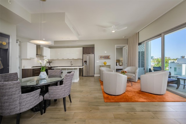 dining area featuring light wood-style flooring, baseboards, and ceiling fan