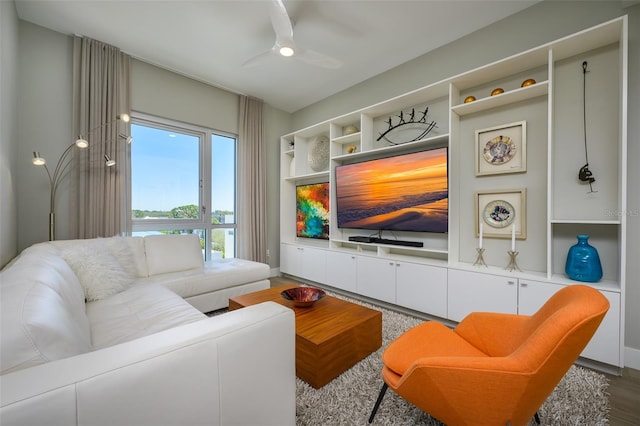 living room featuring a ceiling fan, built in features, and wood finished floors