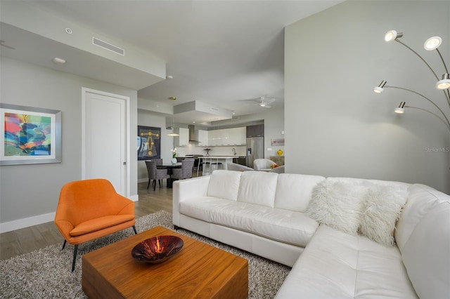 living area featuring wood finished floors, visible vents, and baseboards