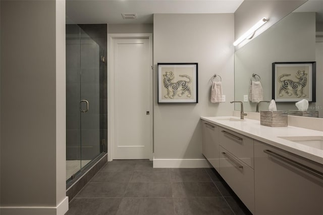 full bath with baseboards, visible vents, double vanity, a stall shower, and a sink