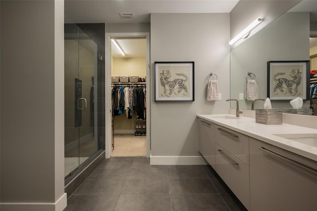 bathroom with visible vents, a stall shower, a sink, double vanity, and a spacious closet