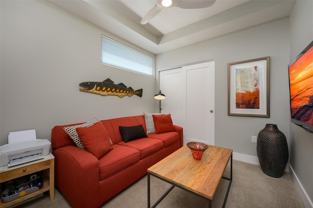 carpeted living area with a ceiling fan and baseboards