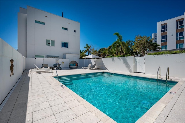 pool with a patio, a gate, and a fenced backyard