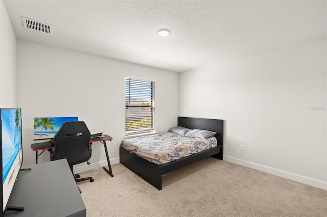 carpeted bedroom with visible vents, a textured ceiling, and baseboards