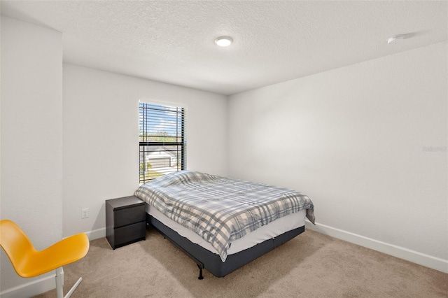 bedroom with carpet, baseboards, and a textured ceiling