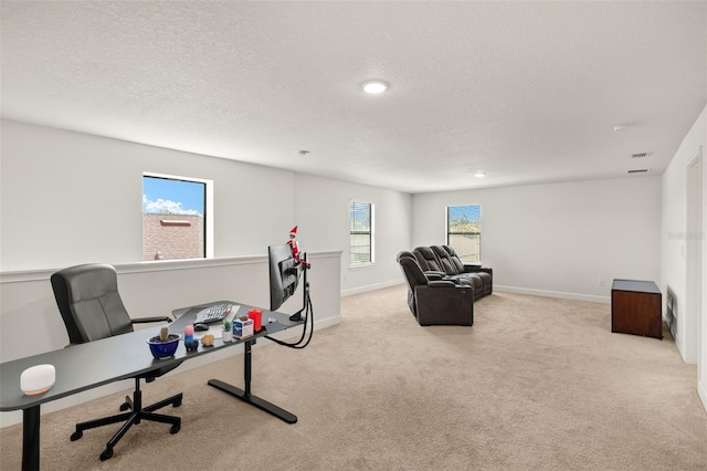 carpeted office space featuring a textured ceiling and baseboards