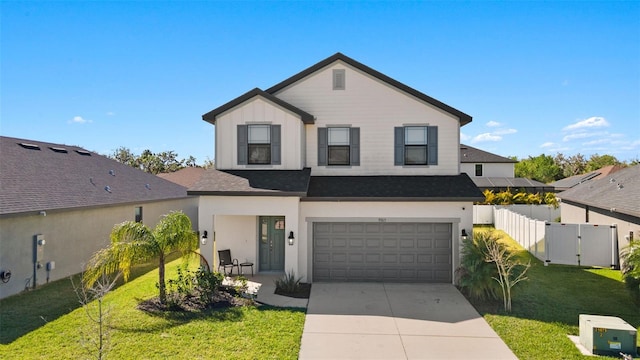 traditional-style house with a front lawn, fence, a garage, and driveway