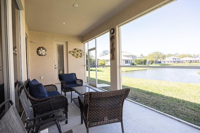 sunroom featuring a water view