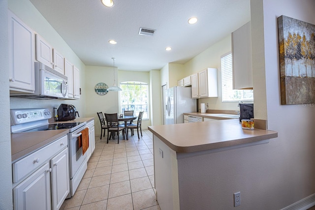 kitchen featuring visible vents, light countertops, light tile patterned floors, white cabinets, and white appliances