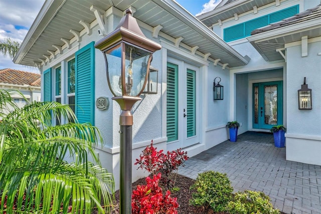 entrance to property featuring stucco siding and french doors