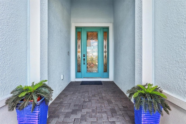 entrance to property featuring stucco siding