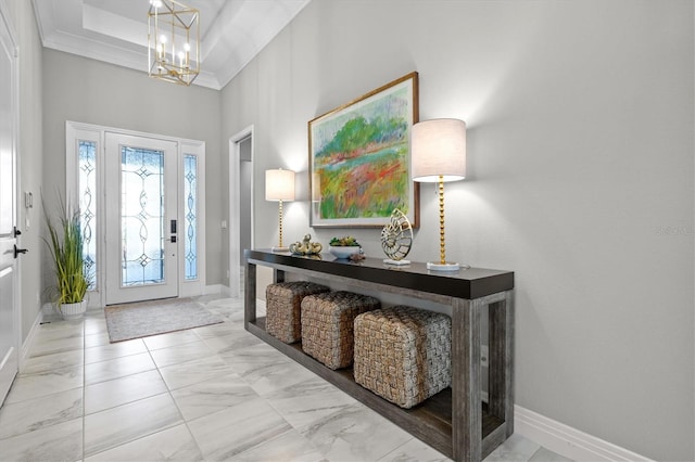 entrance foyer featuring marble finish floor, baseboards, crown molding, and an inviting chandelier