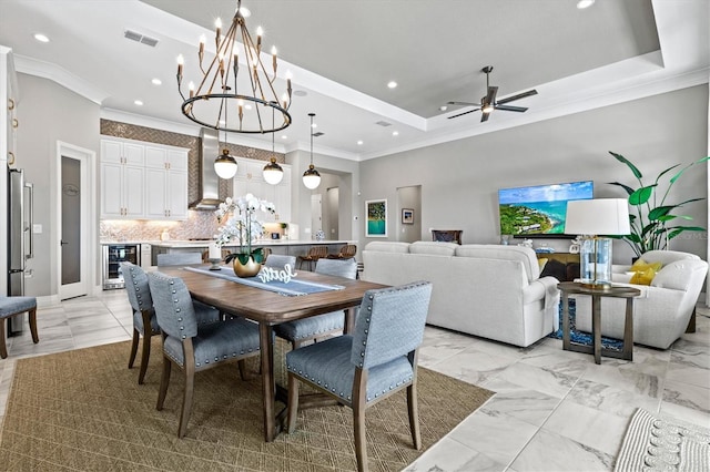 dining room with a tray ceiling, beverage cooler, and ornamental molding