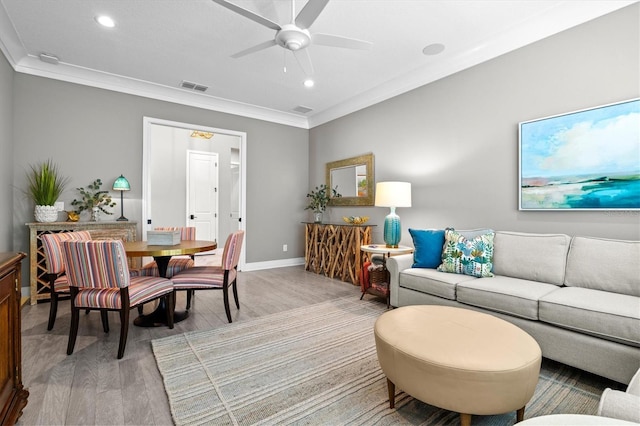 living area featuring visible vents, light wood-style flooring, and crown molding