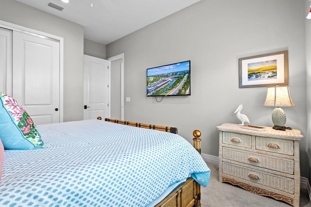 bedroom with a closet, visible vents, baseboards, and carpet floors