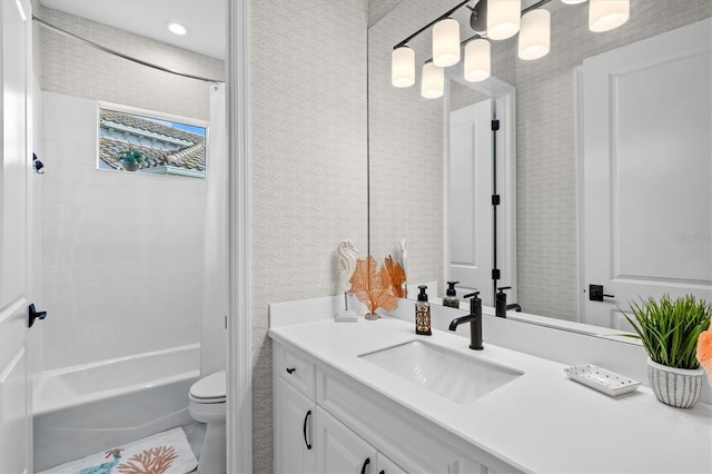 full bathroom featuring wallpapered walls, toilet, vanity, and shower / bathing tub combination