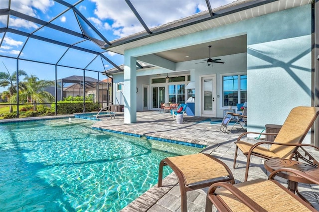 pool featuring glass enclosure, a ceiling fan, and a patio