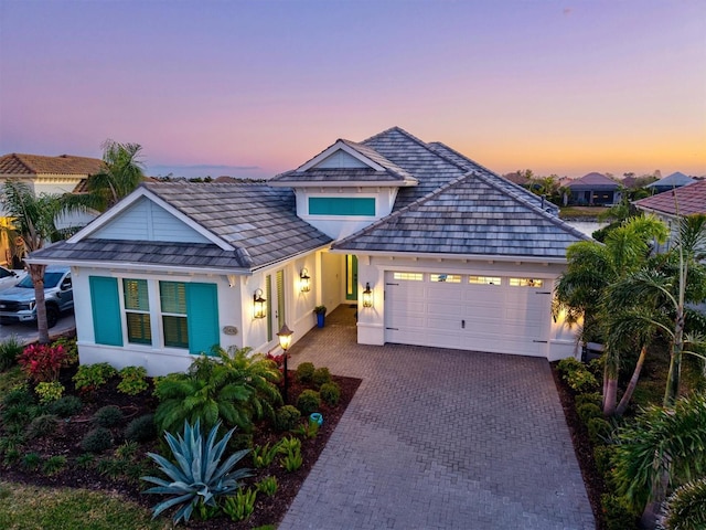 view of front of house with a garage, driveway, and stucco siding