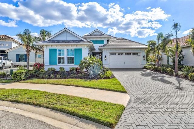 view of front of house with stucco siding, decorative driveway, and a garage