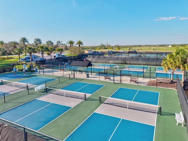 view of tennis court featuring community basketball court and fence