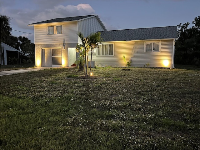 traditional home with a garage, concrete driveway, and a front lawn