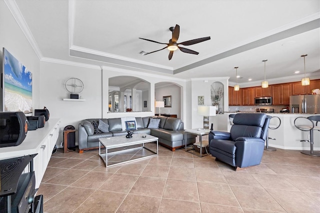 living area featuring a tray ceiling, light tile patterned flooring, crown molding, and ceiling fan