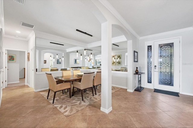 dining room featuring ornamental molding, arched walkways, visible vents, and baseboards